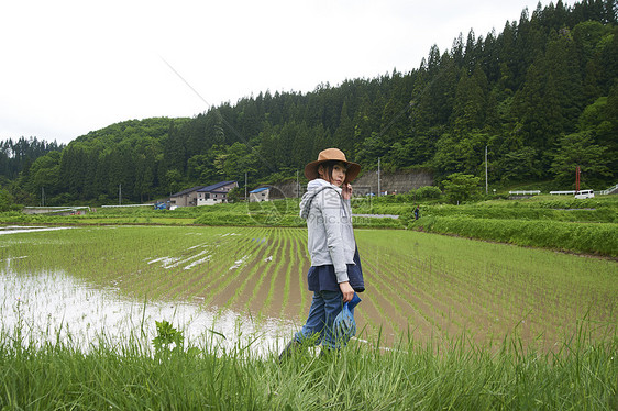 种植水稻后在田里休息的年轻农民图片