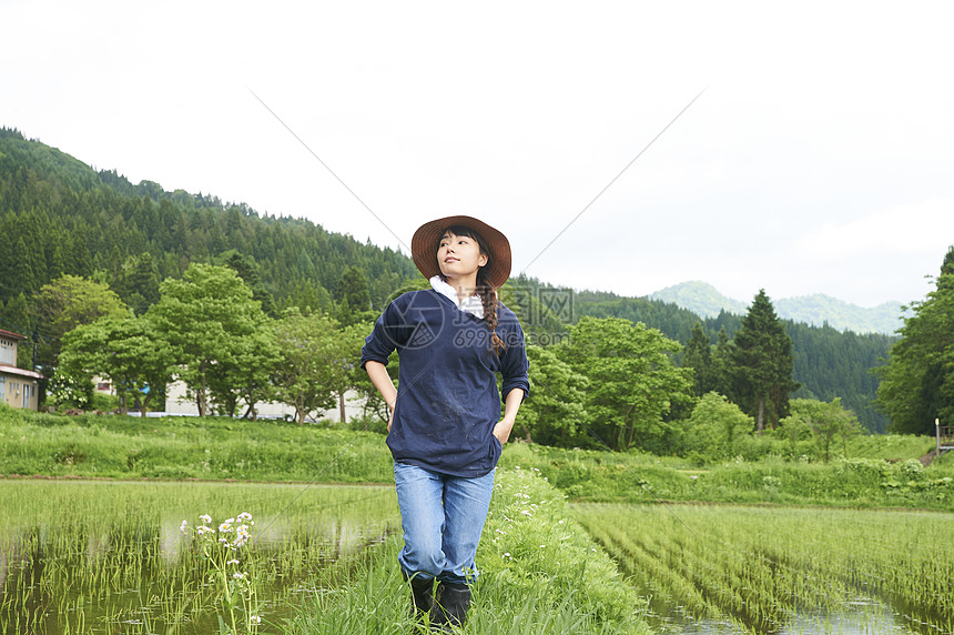 种植水稻后在田里休息的年轻农民图片