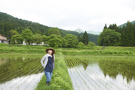 种植水稻后在田里休息的年轻农民图片