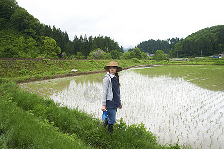 种植水稻后在田里休息的年轻农民图片