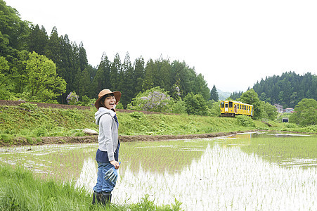 田间给路过汽车打招呼的农民图片