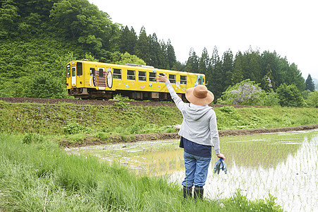 田间给路过汽车打招呼的农民图片