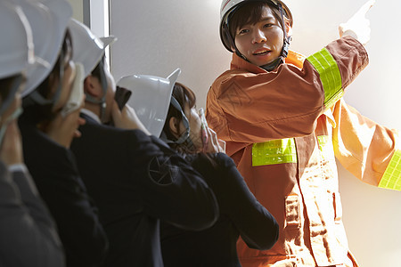 消防员带领公司职员进行救生疏散演习图片