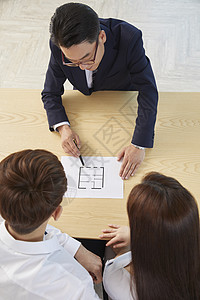 夫妻和房产经纪人讨论户型图背景图片