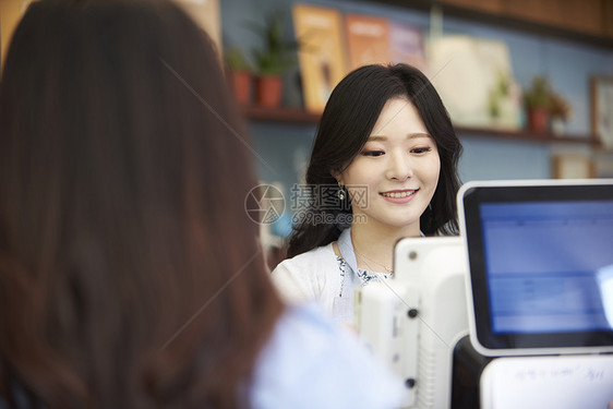 年轻女子在咖啡店当收银员图片