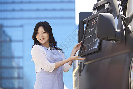 店员在食品车旁介绍着菜单图片