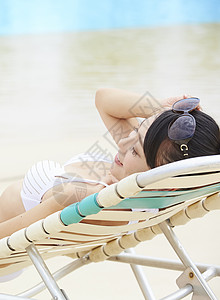 躺在沙滩椅上放松休息的年轻女性图片
