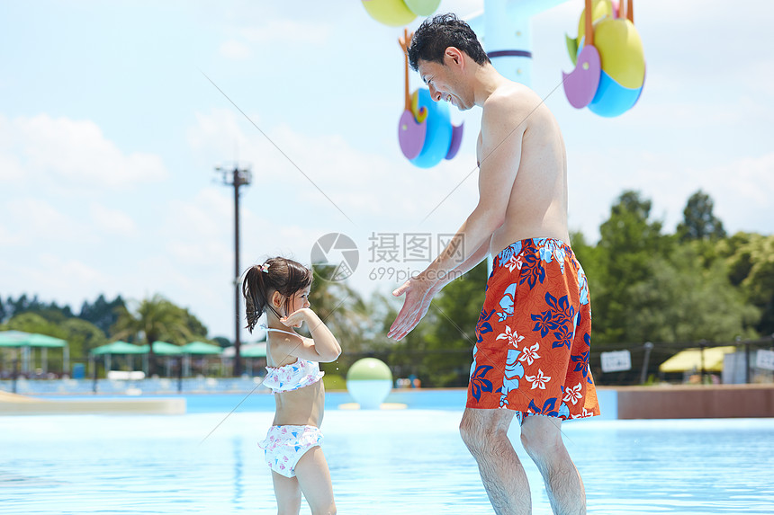游泳池里陪着孩子玩耍的父亲图片