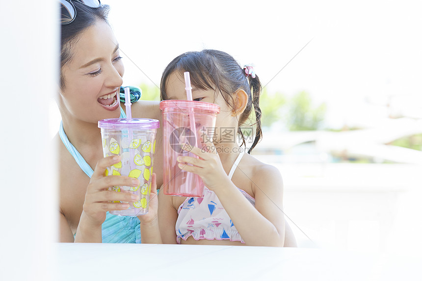 妈妈和女儿在水上乐园喝饮料图片
