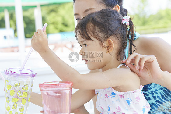 泳池边喝水的母女图片