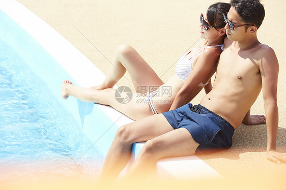 游泳池旁边的年轻情侣图片