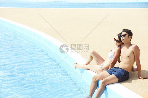 游泳池旁边的年轻情侣图片