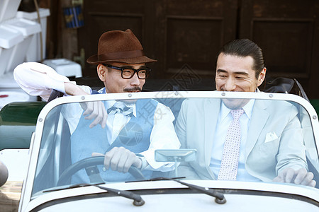 两个坐在复古汽车里的男性图片