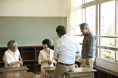 教室里回忆学生时光的老年校友图片