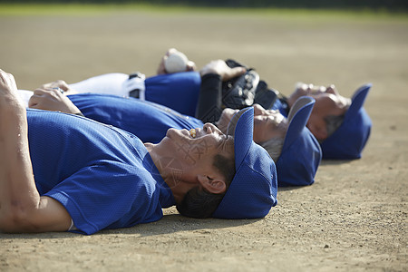 中老年人棒球爱好者躺在草地上休息背景图片