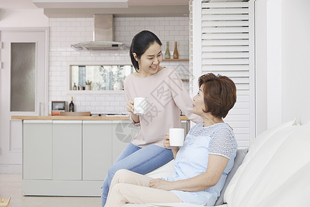 女儿陪妈妈在沙发上喝咖啡图片