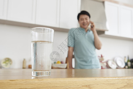 男子打电话前桌子上水杯图片