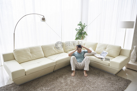 烦恼的中年男人靠在沙发图片