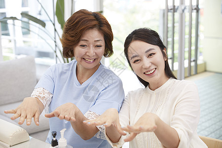 母女在美容化妆品店做美甲背景图片