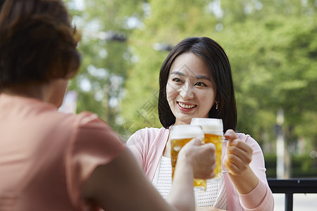 母亲和女儿一起在户外喝啤酒图片