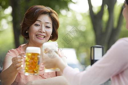 母亲和女儿一起在户外喝啤酒图片