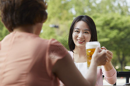 母亲和女儿一起在户外喝啤酒图片