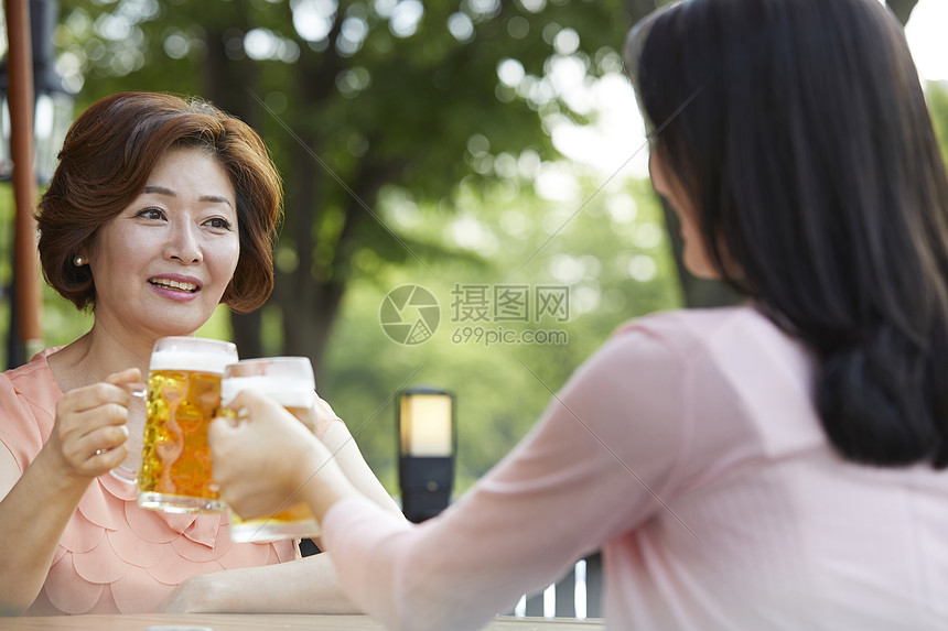 母亲和女儿一起在户外喝啤酒图片