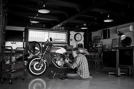 修理摩托车的老人图片