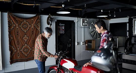 车棚修理摩托车的老人图片