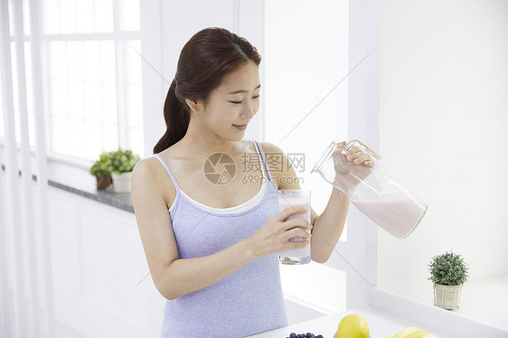 室内美丽的少女喝牛奶图片