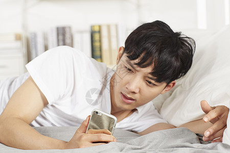 青少年躺在床上玩手机图片