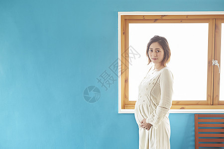 站在窗口边上的怀孕女生图片
