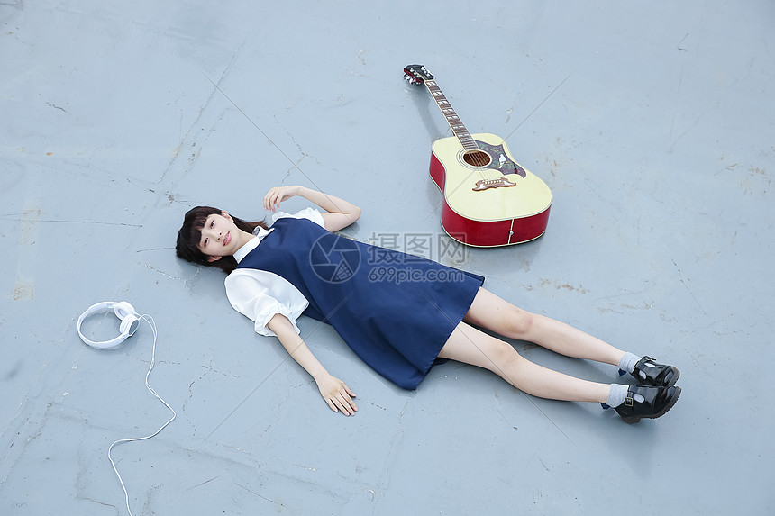 躺在地上的女孩和她的吉他图片
