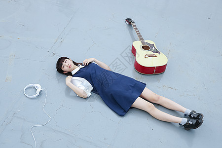 躺在天台的地上放松的高中女孩图片