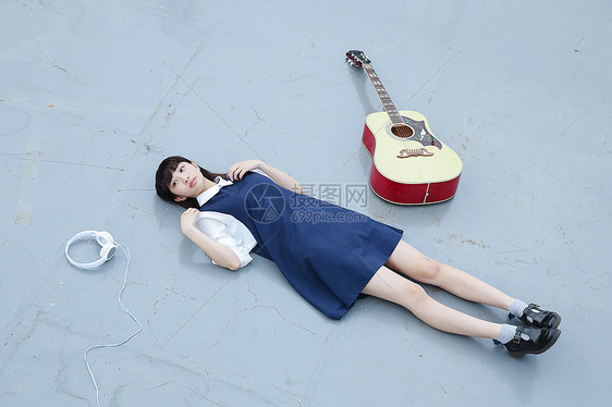 躺在天台的地上放松的高中女孩图片