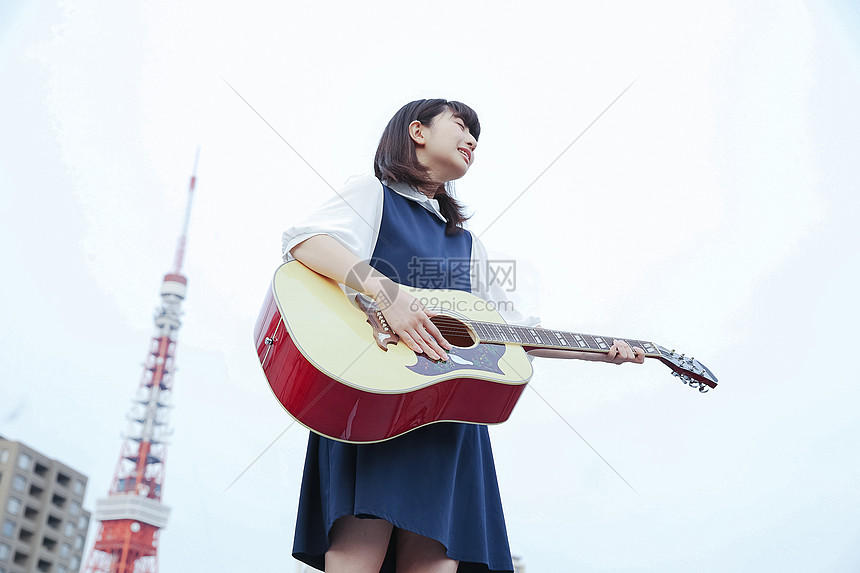 室外弹吉他的女孩图片