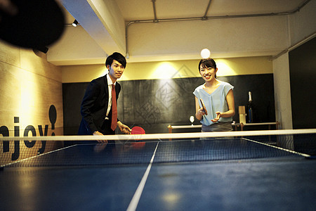 快乐的女孩愉快打乒乓球的夫妇图片