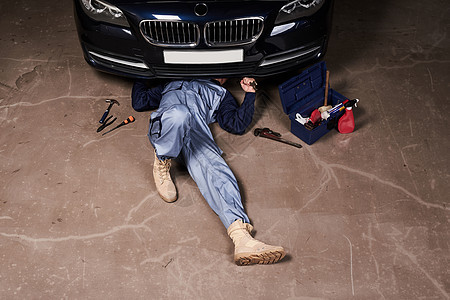 躺在地上维修汽车的机械师图片