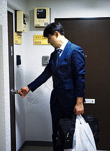 下班回家打开房门的成年男性图片素材