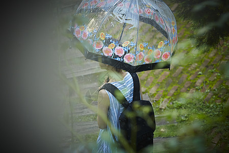 撑伞坐在户外的年轻女孩图片