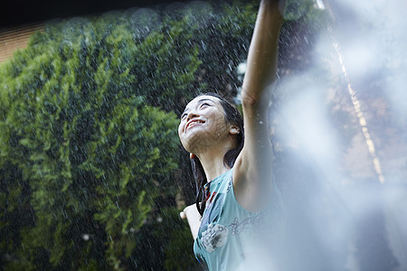 在雨中张开双臂的年轻女孩图片