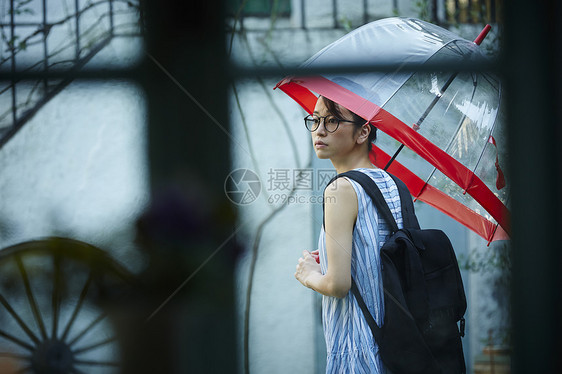 撑伞彷徨的戴眼镜的美女图片