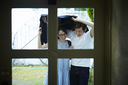 拿外套挡雨的情侣图片素材