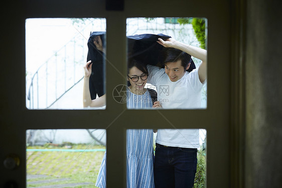 拿外套挡雨的情侣图片