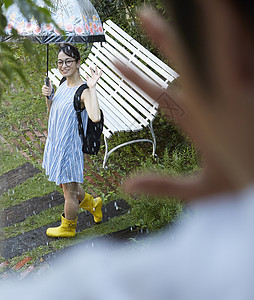 男朋友隔着玻璃在跟室外打着伞的女友挥手图片