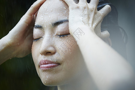 忧郁女性在雨中淋雨图片