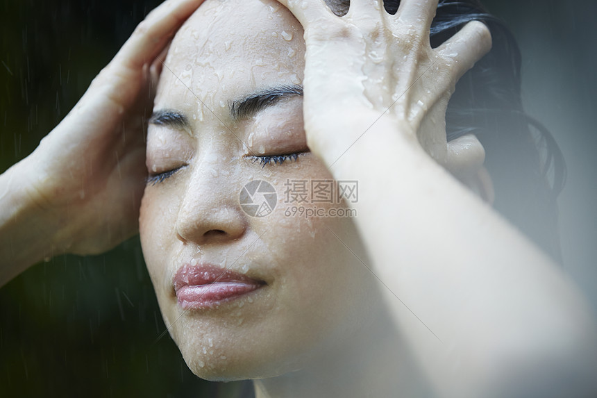 忧郁女性在雨中淋雨图片