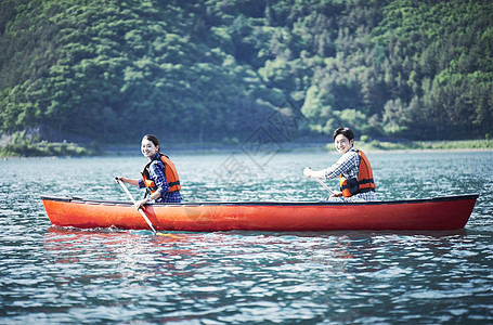 玩救生衣乐在其中划独木舟的夫妇背景图片