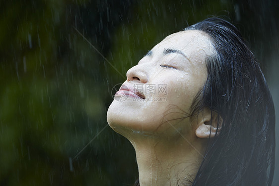 享受雨天的年轻女人图片