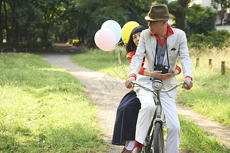 双人自行车骑自行车的老年夫妇背景
